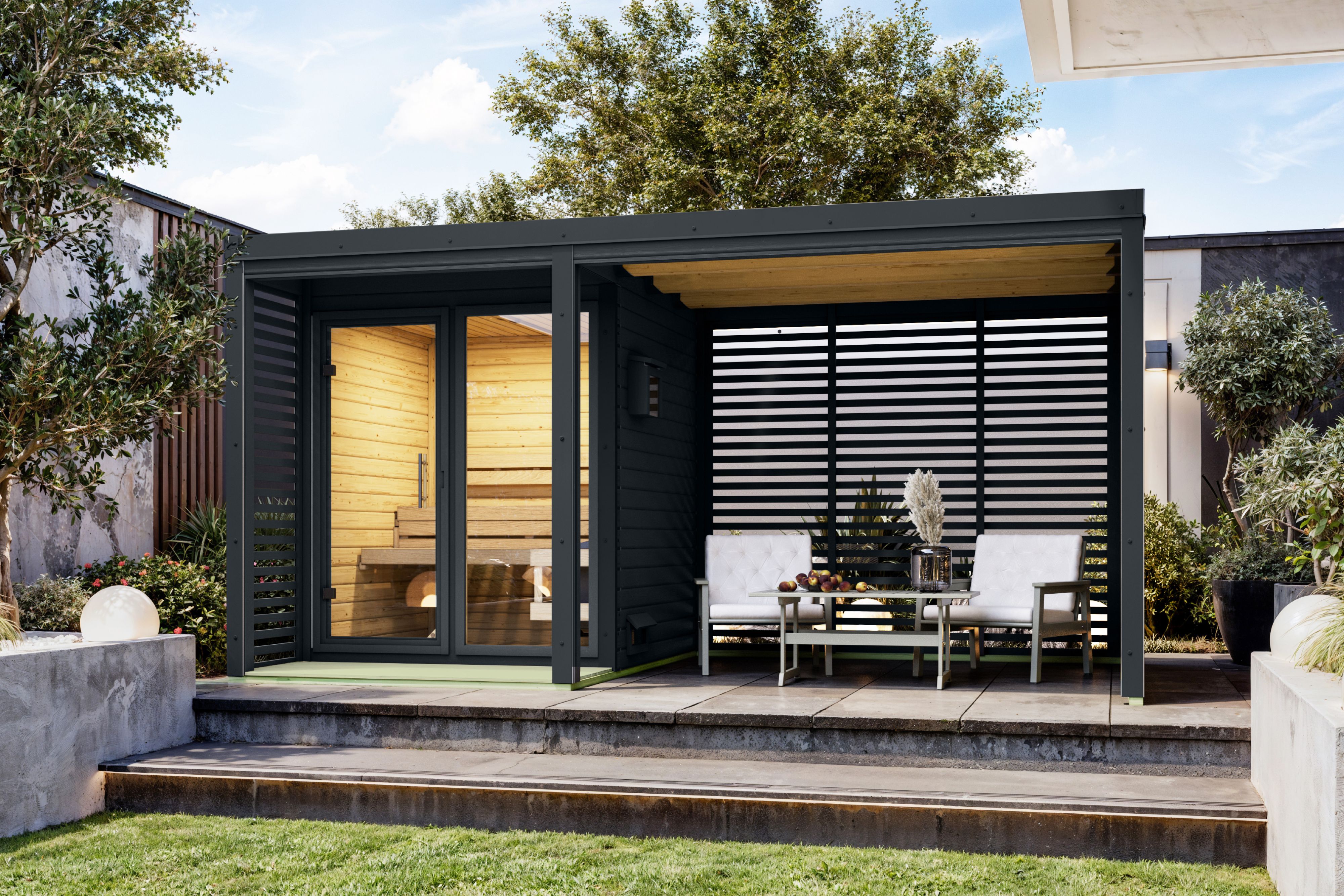 Karibu Saunahaus Ares 1 mit 2,70 m Anbaudach als Gartensauna aus Massivholz im Garten mit Glasfront
