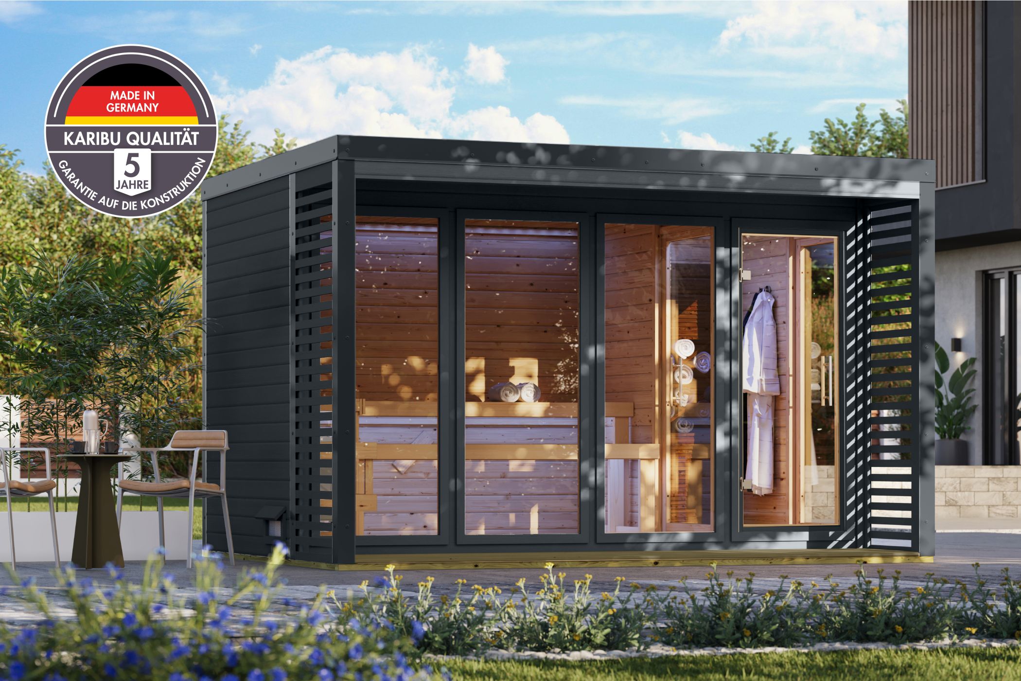 Karibu Saunahaus Ares 4 als Gartensauna aus Massivholz im Garten mit Glasfront